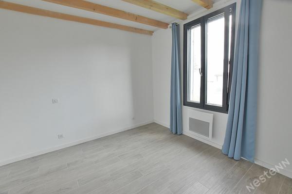 Maison de ville rénovée située dans un quartier résidentiel.