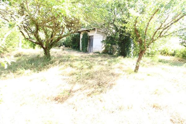 A vendre une grande maison en pierre avec un jardin clôturé, un grand garage de 132m² et une grange de 30m².