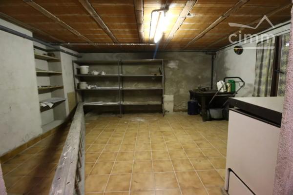 A vendre une grande maison en pierre avec un jardin clôturé, un grand garage de 132m² et une grange de 30m².