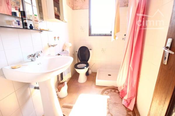 A vendre une grande maison en pierre avec un jardin clôturé, un grand garage de 132m² et une grange de 30m².