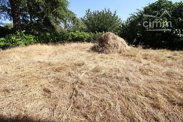 A vendre une grande maison en pierre avec un jardin clôturé, un grand garage de 132m² et une grange de 30m².