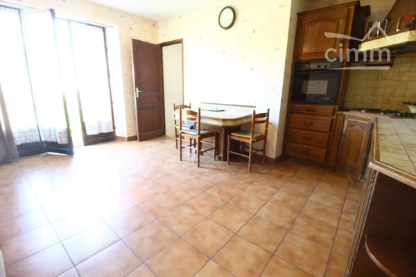 A vendre une grande maison en pierre avec un jardin clôturé, un grand garage de 132m² et une grange de 30m².