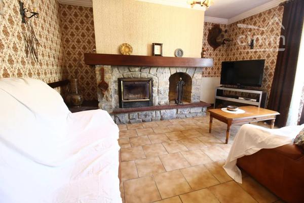 A vendre une grande maison en pierre avec un jardin clôturé, un grand garage de 132m² et une grange de 30m².