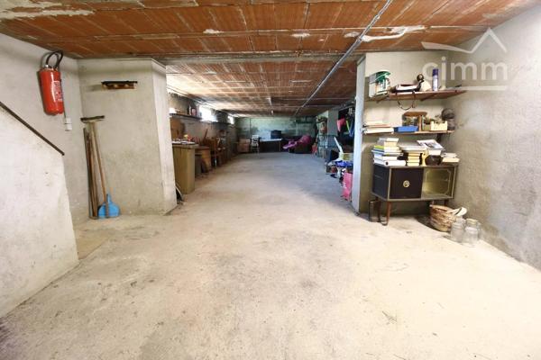 A vendre une grande maison en pierre avec un jardin clôturé, un grand garage de 132m² et une grange de 30m².