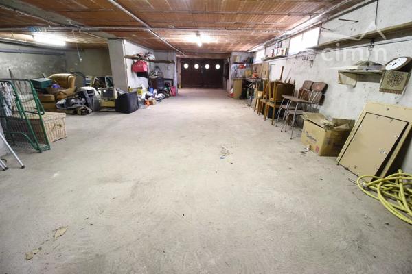 A vendre une grande maison en pierre avec un jardin clôturé, un grand garage de 132m² et une grange de 30m².