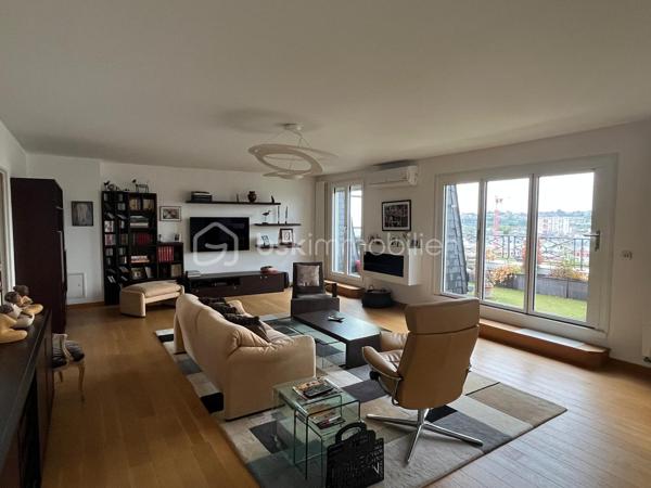 Un appartement familial aux volumes rares, au dernier étage d’une résidence sécurisée, avec terrasse, vue dégagée et double garage privatif.
Au cœur du secteur Centre-ville / Gare, à proximité du Palais des Congrès, découvrez cet appartement traversant de 180 m², situé au 4e et dernier étage avec ascenseur.
Dès l’entrée, les volumes et la luminosité s’imposent. La pièce maîtresse de l’appartement est une vaste pièce de vie d’environ 65 m², largement ouverte sur l’extérieur et prolongée par une terrasse offrant une vue dégagée.
La cuisine, aménagée et équipée, se complète d’une arrière-cuisine, offrant un espace supplémentaire particulièrement appréciable au quotidien.
L’espace nuit se compose de quatre chambres, permettant de répondre aussi bien aux besoins d’une famille qu’à ceux d’un couple recherchant des espaces dédiés au télétravail, aux invités ou aux loisirs.
La suite parentale dispose de sa propre salle d’eau et d’un dressing. Une seconde salle d’eau, des WC séparés et de nombreux placards complètent l’ensemble.
Côté confort, le séjour et la grande chambre bénéficient d’une climatisation réversible, permettant notamment de rafraîchir ces pièces en période estivale. Le chauffage de l’immeuble est assuré par une installation collective au gaz avec chaudière collective.
En complément, l’appartement dispose d’un double garage fermé privatif en sous-sol, équipé en électricité et éclairage, ainsi que d’une cave.
Avec ses 180 m² habitables, son dernier étage, sa terrasse et son double garage, cet appartement offre une configuration particulièrement peu commune en centre-ville. Un bien pensé pour celles et ceux qui recherchent de grands volumes, plusieurs espaces de vie et de travail, un extérieur et un stationnement privatif, tout en restant à proximité immédiate des commodités.