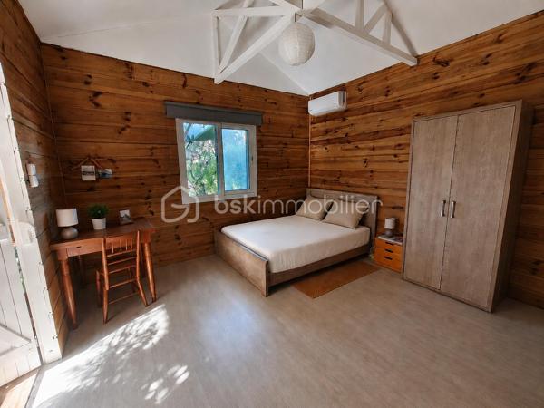 Idéalement située dans le quartier très recherché de Grand Fond, à quelques minutes à pied des plages de Saint-Gilles-les-Bains, cette villa de caractère vous séduira par son charme créole, son environnement verdoyant et son fort potentiel.
Édifiée sur une magnifique parcelle arborée de 940m², la maison principale offre environ 116m² habitables. 
Dès l'entrée vous serez séduit par une belle pièce de vie d'environ 48m², réunissant salon, séjour et cuisine ouverte dans une ambiance chaleureuse. La belle hauteur sous plafond, les poutres apparentes et les nombreuses ouvertures sur le jardin et la varangue apportent une agréable sensation d'espace et une belle luminosité naturelle.

La villa principale se compose de :
- Une chambre avec salle d'eau et WC.
- Deux chambres supplémentaires.
- Une seconde salle d'eau.
- Un WC indépendant.

À l'extérieur, vous profiterez d'une superbe varangue couverte de 65m², véritable pièce de vie ouverte sur un jardin tropical paysager, offrant plusieurs espaces de détente dans un environnement calme et intimiste.
Un bungalow indépendant d'environ 20m² complète la propriété. Il comprend une chambre, un coin cuisine ainsi qu'une salle d'eau avec WC. Cet espace est idéal pour accueillir famille et amis ou développer une activité de location saisonnière.

Les atouts:
Quartier recherché de Grand Fond
Terrain arboré de 940 m²
Grande varangue de 65 m²
Bungalow indépendant
Charme créole et ambiance tropicale
Fort potentiel en résidence principale, secondaire ou investissement locatif