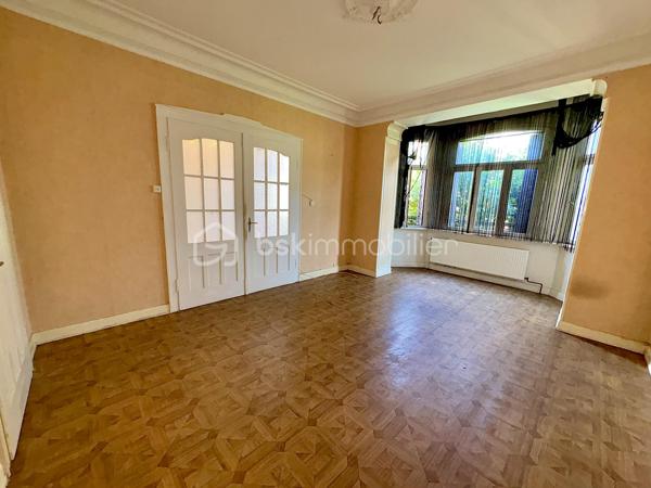 Située à Sarreguemines, cette maison mitoyenne d’un côté, d’environ 135 m², offre un beau potentiel pour les amateurs de rénovation et les projets immobiliers.

Répartie sur plusieurs niveaux, elle dispose actuellement de nombreux espaces pouvant être repensés selon les besoins : au rez-de-chaussée, vous trouverez notamment un séjour, un salon, une cuisine, une chambre ainsi qu’une salle d’eau.

Le premier étage propose également plusieurs pièces de vie, une cuisine, une chambre et une salle de bains. Les combles offrent quant à eux deux espaces supplémentaires pouvant être aménagés en chambres ou selon les envies.

La maison bénéficie également d’une petite loggia fermée accessible depuis l’étage, apportant un espace supplémentaire et une ouverture agréable sur l’extérieur.

La configuration actuelle, avec ses différents espaces et ses deux cuisines, peut permettre d’envisager plusieurs projets : créer une grande habitation familiale, repenser entièrement les volumes ou réfléchir à un projet locatif, sous réserve des travaux et autorisations nécessaires.

À l’extérieur, le bien dispose d’un garage pouvant accueillir deux véhicules, d’une cave ainsi que d’un grand jardin à l’arrière.

L’ensemble nécessite une rénovation complète. Cette maison s’adresse donc particulièrement aux personnes à la recherche d’un véritable projet de rénovation, avec la possibilité de transformer et de moderniser les espaces selon leurs besoins et leurs envies.

Une belle opportunité pour révéler le potentiel de cette ancienne maison et lui donner une nouvelle vie.