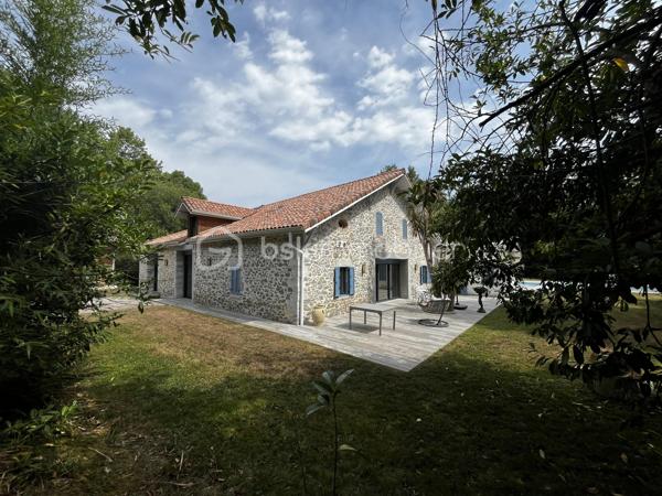 FERME LANDAISE 399 m² – 6,7 HA – PISCINE – 4 CHAMBRES – RÉNOVATION COMPLÈTE

Située à 20 minutes des portes de Bayonne  et 25 minutes des plages de Capbreton et Hossegor.

Rare sur le secteur : propriété de 399 m² habitables sur 6,7 hectares, entièrement rénovée, avec piscine, spa et dépendance.

Cette ancienne ferme landaise datant de 1850 a été entièrement rénovée en 2018-2019. Elle offre de grands volumes, quatre chambres avec sanitaires privatifs, deux cuisines et de nombreuses dépendances, le tout dans un environnement calme et sans vis-à-vis.

UNE MAISON DE 399 m² HABITABLES

La maison se compose de :

* Vaste séjour lumineux avec poutres apparentes et poêle à bois scandinave
* Bibliothèque
* Deux cuisines, dont une cuisine principale et une seconde cuisine adaptée aux réceptions
* 4 chambres
* Suite parentale au rez-de-chaussée avec accès extérieur, salle de bains et WC
* 3 chambres à l’étage, chacune avec salle d’eau et WC
* Climatisation réversible dans toutes les chambres

La distribution permet d’accueillir confortablement une grande famille ou plusieurs générations, avec une réelle indépendance pour chaque espace nuit.

RÉNOVATION IMPORTANTE

La propriété a fait l’objet d’une rénovation complète entre 2018 et 2019 :

* Toiture entièrement refaite
* Menuiseries remplacées en aluminium double vitrage
* Portes et baies vitrées neuves
* Volumes intérieurs ouverts et réorganisés
* Deux cuisines créées/aménagées
* Salles d’eau et sanitaires rénovés
* Poêle à bois scandinave
* Climatisation réversible dans les chambres
* Piscine et spa

Le chauffage principal est assuré par une chaudière gaz avec citerne enterrée.

Un suivi régulier du traitement anti-termites est également réalisé, avec dossier disponible.

6,7 HECTARES AVEC PISCINE ET DÉPENDANCES

Le terrain de 6,7 hectares est composé de bois et de pâtures, avec un parc arboré entretenu.

La propriété bénéficie d’un environnement sans vis-à-vis, offrant calme et intimité.

Côté extérieur :

* Piscine au sel avec volet électrique de sécurité
* Spa 6 places
* Garage spacieux
* Dépendance d’environ 30 m² avec salle d’eau et WC

Cette dépendance peut être aménagée selon les besoins : studio, bureau, atelier, espace professionnel ou logement d’appoint, sous réserve des autorisations nécessaires.

LES + DU BIEN

399 m² habitables
6,7 hectares
Ferme de 1850
Rénovation 2018-2019
4 chambres
4 espaces sanitaires privatifs pour les chambres
2 cuisines
Piscine au sel
Spa 6 places
Dépendance de 30 m² avec salle d’eau et WC
Garage
Terrain composé de bois et pâtures
Aucun vis-à-vis
Environ 30 minutes des plages

Une propriété offrant un volume et une surface de terrain particulièrement rares, avec des travaux importants déjà réalisés.

Diagnostics et dossier technique disponibles sur demande.

Contactez-nous pour obtenir davantage d’informations ou organiser une visite.