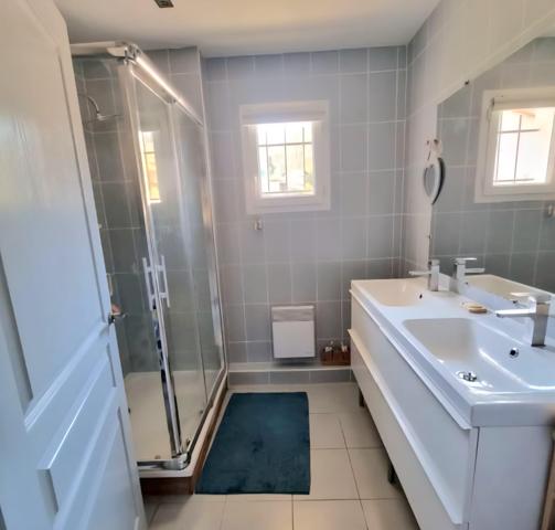 Maison mitoyenne, 3 chambres, garage et stationnement sur 333 m2 de terrain clos.