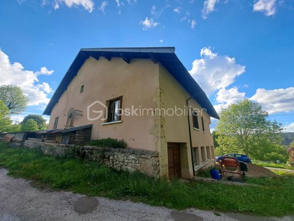 Situé à La Mouille – Hauts de Bienne (39400), à seulement 15 km de la frontière suisse, ancien relais douanier en pierres offrant un fort potentiel de rénovation et d’aménagement.

Édifiée sur un terrain de 3 796 m², cette bâtisse de caractère développe environ 200 m² au sol répartis sur 3 niveaux, avec de très beaux volumes et une belle hauteur sous plafond.

Une partie habitable d’environ 60 m² est déjà aménagée au 1er étage et comprend :
une cuisine ouverte sur la pièce de vie, une chambre, une salle de bain, un WC.

Le reste du bâtiment offre d’importants espaces à réhabiliter avec plusieurs volumes sur deux niveaux, laissant libre cours à de nombreux projets :
grande maison familiale, création de plusieurs logements, investissement locatif, gîtes ou activité touristique.

Les travaux de rénovation ont déjà été engagés :
une partie des dalles est réalisée, structure et volumes déjà ouverts, nombreuses ouvertures apportant une belle luminosité, grandes fenêtres au rez-de-chaussée.
La toiture est en bon état.
Le bien est raccordé au tout-à-l’égout.
Fenêtres présentes sur tous les niveaux en simple vitrage.
Le matériel nécessaire à la réalisation des dalles restantes est vendu avec le bien.
Une petite dépendance d’environ 30 m² complète la propriété.