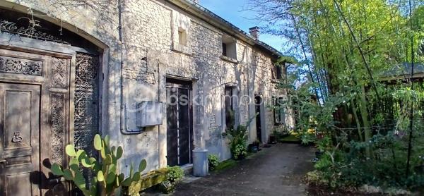 À seulement 1 km maximum de la ville et de toutes les commodités, au bout d’un chemin paisible où le silence n’est troublé que par la nature, découvrez cette magnifique maison en pierres de taille et moellons datant des années 1900, non mitoyenne, nichée au cœur d’un écrin de verdure de 5 191 m². Une propriété rare de 379 m² habitables, idéale pour les amoureux de calme, d’espace et d’authenticité.

Dès l’entrée, les volumes impressionnent : un séjour de 64 m² sublimé par une mezzanine de 40 m² qui surplombe la pièce et renforce le cachet et le caractère des lieux, un petit salon plus intime pour recevoir, une grande salle à manger conviviale et une cuisine séparée, moderne, aménagée et équipée. La maison offre au rez-de-chaussée une belle chambre de 20 m² avec sa suite parentale comprenant salle de bain, douche et toilettes séparées, ainsi qu’un WC indépendant. Deux cheminées agrémentent la maison, dont une avec insert, apportant chaleur et atmosphère d’antan. Au rez-de-chaussée, les ouvertures sont en double vitrage bois et les baies vitrées en aluminium, alliant confort et respect du style de la bâtisse.

À l’étage, trois chambres de 17 m², 14 m² et 13 m² se partagent un palier de 8 m². Les fenêtres y sont en simple vitrage, conservant l’esprit authentique de l’étage.

Un studio indépendant de 60 m², entièrement refait à neuf, complète ce bien et offre de très belles possibilités. Il dispose d’une chambre de 16 m², d’une agréable pièce de vie de 25 m² avec cuisine équipée, d’une salle de bain neuve, d’une salle d’eau avec cabine de douche, d’un WC séparé ainsi que d’un coin nuit avec lits superposés. À l’entrée du studio, une terrasse avec auvent accueille table et chaises pour profiter des beaux jours en toute tranquillité. Idéal pour recevoir famille et amis, développer une activité professionnelle ou envisager un projet locatif.

À l’extérieur, le terrain arboré de 5 191 m² invite à la détente avec une piscine 9 x 4,5 m, une cuisine d’été, un grand garage de 130 m² et une cave. La toiture est en bon état. L’assainissement est individuel et non conforme.

Le DPE est classé C en performance énergétique et A en émissions de gaz à effet de serre, un excellent équilibre pour une demeure de caractère. La maison est équipée d’une chaudière à pellets nouvelle génération assurant un confort performant et économique.

Les matériaux utilisés sont de bonne qualité, alliant robustesse et longévité, dans le respect du bâti ancien. Cette propriété séduira particulièrement les amoureux de l’authenticité, de la pierre et des demeures de caractère, à la recherche d’un lieu chargé d’histoire où le charme de l’ancien s’exprime pleinement, tout en restant proche de la ville.