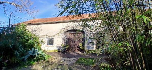 À seulement 1 km maximum de la ville et de toutes les commodités, au bout d’un chemin paisible où le silence n’est troublé que par la nature, découvrez cette magnifique maison en pierres de taille et moellons datant des années 1900, non mitoyenne, nichée au cœur d’un écrin de verdure de 5 191 m². Une propriété rare de 379 m² habitables, idéale pour les amoureux de calme, d’espace et d’authenticité.

Dès l’entrée, les volumes impressionnent : un séjour de 64 m² sublimé par une mezzanine de 40 m² qui surplombe la pièce et renforce le cachet et le caractère des lieux, un petit salon plus intime pour recevoir, une grande salle à manger conviviale et une cuisine séparée, moderne, aménagée et équipée. La maison offre au rez-de-chaussée une belle chambre de 20 m² avec sa suite parentale comprenant salle de bain, douche et toilettes séparées, ainsi qu’un WC indépendant. Deux cheminées agrémentent la maison, dont une avec insert, apportant chaleur et atmosphère d’antan. Au rez-de-chaussée, les ouvertures sont en double vitrage bois et les baies vitrées en aluminium, alliant confort et respect du style de la bâtisse.

À l’étage, trois chambres de 17 m², 14 m² et 13 m² se partagent un palier de 8 m². Les fenêtres y sont en simple vitrage, conservant l’esprit authentique de l’étage.

Un studio indépendant de 60 m², entièrement refait à neuf, complète ce bien et offre de très belles possibilités. Il dispose d’une chambre de 16 m², d’une agréable pièce de vie de 25 m² avec cuisine équipée, d’une salle de bain neuve, d’une salle d’eau avec cabine de douche, d’un WC séparé ainsi que d’un coin nuit avec lits superposés. À l’entrée du studio, une terrasse avec auvent accueille table et chaises pour profiter des beaux jours en toute tranquillité. Idéal pour recevoir famille et amis, développer une activité professionnelle ou envisager un projet locatif.

À l’extérieur, le terrain arboré de 5 191 m² invite à la détente avec une piscine 9 x 4,5 m, une cuisine d’été, un grand garage de 130 m² et une cave. La toiture est en bon état. L’assainissement est individuel et non conforme.

Le DPE est classé C en performance énergétique et A en émissions de gaz à effet de serre, un excellent équilibre pour une demeure de caractère. La maison est équipée d’une chaudière à pellets nouvelle génération assurant un confort performant et économique.

Les matériaux utilisés sont de bonne qualité, alliant robustesse et longévité, dans le respect du bâti ancien. Cette propriété séduira particulièrement les amoureux de l’authenticité, de la pierre et des demeures de caractère, à la recherche d’un lieu chargé d’histoire où le charme de l’ancien s’exprime pleinement, tout en restant proche de la ville.