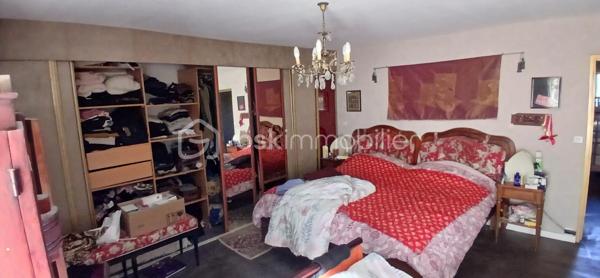 À seulement 1 km maximum de la ville et de toutes les commodités, au bout d’un chemin paisible où le silence n’est troublé que par la nature, découvrez cette magnifique maison en pierres de taille et moellons datant des années 1900, non mitoyenne, nichée au cœur d’un écrin de verdure de 5 191 m². Une propriété rare de 379 m² habitables, idéale pour les amoureux de calme, d’espace et d’authenticité.

Dès l’entrée, les volumes impressionnent : un séjour de 64 m² sublimé par une mezzanine de 40 m² qui surplombe la pièce et renforce le cachet et le caractère des lieux, un petit salon plus intime pour recevoir, une grande salle à manger conviviale et une cuisine séparée, moderne, aménagée et équipée. La maison offre au rez-de-chaussée une belle chambre de 20 m² avec sa suite parentale comprenant salle de bain, douche et toilettes séparées, ainsi qu’un WC indépendant. Deux cheminées agrémentent la maison, dont une avec insert, apportant chaleur et atmosphère d’antan. Au rez-de-chaussée, les ouvertures sont en double vitrage bois et les baies vitrées en aluminium, alliant confort et respect du style de la bâtisse.

À l’étage, trois chambres de 17 m², 14 m² et 13 m² se partagent un palier de 8 m². Les fenêtres y sont en simple vitrage, conservant l’esprit authentique de l’étage.

Un studio indépendant de 60 m², entièrement refait à neuf, complète ce bien et offre de très belles possibilités. Il dispose d’une chambre de 16 m², d’une agréable pièce de vie de 25 m² avec cuisine équipée, d’une salle de bain neuve, d’une salle d’eau avec cabine de douche, d’un WC séparé ainsi que d’un coin nuit avec lits superposés. À l’entrée du studio, une terrasse avec auvent accueille table et chaises pour profiter des beaux jours en toute tranquillité. Idéal pour recevoir famille et amis, développer une activité professionnelle ou envisager un projet locatif.

À l’extérieur, le terrain arboré de 5 191 m² invite à la détente avec une piscine 9 x 4,5 m, une cuisine d’été, un grand garage de 130 m² et une cave. La toiture est en bon état. L’assainissement est individuel et non conforme.

Le DPE est classé C en performance énergétique et A en émissions de gaz à effet de serre, un excellent équilibre pour une demeure de caractère. La maison est équipée d’une chaudière à pellets nouvelle génération assurant un confort performant et économique.

Les matériaux utilisés sont de bonne qualité, alliant robustesse et longévité, dans le respect du bâti ancien. Cette propriété séduira particulièrement les amoureux de l’authenticité, de la pierre et des demeures de caractère, à la recherche d’un lieu chargé d’histoire où le charme de l’ancien s’exprime pleinement, tout en restant proche de la ville.