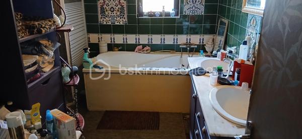 À seulement 1 km maximum de la ville et de toutes les commodités, au bout d’un chemin paisible où le silence n’est troublé que par la nature, découvrez cette magnifique maison en pierres de taille et moellons datant des années 1900, non mitoyenne, nichée au cœur d’un écrin de verdure de 5 191 m². Une propriété rare de 379 m² habitables, idéale pour les amoureux de calme, d’espace et d’authenticité.

Dès l’entrée, les volumes impressionnent : un séjour de 64 m² sublimé par une mezzanine de 40 m² qui surplombe la pièce et renforce le cachet et le caractère des lieux, un petit salon plus intime pour recevoir, une grande salle à manger conviviale et une cuisine séparée, moderne, aménagée et équipée. La maison offre au rez-de-chaussée une belle chambre de 20 m² avec sa suite parentale comprenant salle de bain, douche et toilettes séparées, ainsi qu’un WC indépendant. Deux cheminées agrémentent la maison, dont une avec insert, apportant chaleur et atmosphère d’antan. Au rez-de-chaussée, les ouvertures sont en double vitrage bois et les baies vitrées en aluminium, alliant confort et respect du style de la bâtisse.

À l’étage, trois chambres de 17 m², 14 m² et 13 m² se partagent un palier de 8 m². Les fenêtres y sont en simple vitrage, conservant l’esprit authentique de l’étage.

Un studio indépendant de 60 m², entièrement refait à neuf, complète ce bien et offre de très belles possibilités. Il dispose d’une chambre de 16 m², d’une agréable pièce de vie de 25 m² avec cuisine équipée, d’une salle de bain neuve, d’une salle d’eau avec cabine de douche, d’un WC séparé ainsi que d’un coin nuit avec lits superposés. À l’entrée du studio, une terrasse avec auvent accueille table et chaises pour profiter des beaux jours en toute tranquillité. Idéal pour recevoir famille et amis, développer une activité professionnelle ou envisager un projet locatif.

À l’extérieur, le terrain arboré de 5 191 m² invite à la détente avec une piscine 9 x 4,5 m, une cuisine d’été, un grand garage de 130 m² et une cave. La toiture est en bon état. L’assainissement est individuel et non conforme.

Le DPE est classé C en performance énergétique et A en émissions de gaz à effet de serre, un excellent équilibre pour une demeure de caractère. La maison est équipée d’une chaudière à pellets nouvelle génération assurant un confort performant et économique.

Les matériaux utilisés sont de bonne qualité, alliant robustesse et longévité, dans le respect du bâti ancien. Cette propriété séduira particulièrement les amoureux de l’authenticité, de la pierre et des demeures de caractère, à la recherche d’un lieu chargé d’histoire où le charme de l’ancien s’exprime pleinement, tout en restant proche de la ville.