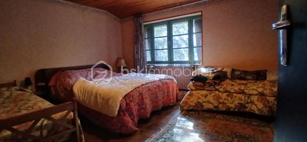 À seulement 1 km maximum de la ville et de toutes les commodités, au bout d’un chemin paisible où le silence n’est troublé que par la nature, découvrez cette magnifique maison en pierres de taille et moellons datant des années 1900, non mitoyenne, nichée au cœur d’un écrin de verdure de 5 191 m². Une propriété rare de 379 m² habitables, idéale pour les amoureux de calme, d’espace et d’authenticité.

Dès l’entrée, les volumes impressionnent : un séjour de 64 m² sublimé par une mezzanine de 40 m² qui surplombe la pièce et renforce le cachet et le caractère des lieux, un petit salon plus intime pour recevoir, une grande salle à manger conviviale et une cuisine séparée, moderne, aménagée et équipée. La maison offre au rez-de-chaussée une belle chambre de 20 m² avec sa suite parentale comprenant salle de bain, douche et toilettes séparées, ainsi qu’un WC indépendant. Deux cheminées agrémentent la maison, dont une avec insert, apportant chaleur et atmosphère d’antan. Au rez-de-chaussée, les ouvertures sont en double vitrage bois et les baies vitrées en aluminium, alliant confort et respect du style de la bâtisse.

À l’étage, trois chambres de 17 m², 14 m² et 13 m² se partagent un palier de 8 m². Les fenêtres y sont en simple vitrage, conservant l’esprit authentique de l’étage.

Un studio indépendant de 60 m², entièrement refait à neuf, complète ce bien et offre de très belles possibilités. Il dispose d’une chambre de 16 m², d’une agréable pièce de vie de 25 m² avec cuisine équipée, d’une salle de bain neuve, d’une salle d’eau avec cabine de douche, d’un WC séparé ainsi que d’un coin nuit avec lits superposés. À l’entrée du studio, une terrasse avec auvent accueille table et chaises pour profiter des beaux jours en toute tranquillité. Idéal pour recevoir famille et amis, développer une activité professionnelle ou envisager un projet locatif.

À l’extérieur, le terrain arboré de 5 191 m² invite à la détente avec une piscine 9 x 4,5 m, une cuisine d’été, un grand garage de 130 m² et une cave. La toiture est en bon état. L’assainissement est individuel et non conforme.

Le DPE est classé C en performance énergétique et A en émissions de gaz à effet de serre, un excellent équilibre pour une demeure de caractère. La maison est équipée d’une chaudière à pellets nouvelle génération assurant un confort performant et économique.

Les matériaux utilisés sont de bonne qualité, alliant robustesse et longévité, dans le respect du bâti ancien. Cette propriété séduira particulièrement les amoureux de l’authenticité, de la pierre et des demeures de caractère, à la recherche d’un lieu chargé d’histoire où le charme de l’ancien s’exprime pleinement, tout en restant proche de la ville.