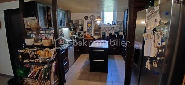 À seulement 1 km maximum de la ville et de toutes les commodités, au bout d’un chemin paisible où le silence n’est troublé que par la nature, découvrez cette magnifique maison en pierres de taille et moellons datant des années 1900, non mitoyenne, nichée au cœur d’un écrin de verdure de 5 191 m². Une propriété rare de 379 m² habitables, idéale pour les amoureux de calme, d’espace et d’authenticité.

Dès l’entrée, les volumes impressionnent : un séjour de 64 m² sublimé par une mezzanine de 40 m² qui surplombe la pièce et renforce le cachet et le caractère des lieux, un petit salon plus intime pour recevoir, une grande salle à manger conviviale et une cuisine séparée, moderne, aménagée et équipée. La maison offre au rez-de-chaussée une belle chambre de 20 m² avec sa suite parentale comprenant salle de bain, douche et toilettes séparées, ainsi qu’un WC indépendant. Deux cheminées agrémentent la maison, dont une avec insert, apportant chaleur et atmosphère d’antan. Au rez-de-chaussée, les ouvertures sont en double vitrage bois et les baies vitrées en aluminium, alliant confort et respect du style de la bâtisse.

À l’étage, trois chambres de 17 m², 14 m² et 13 m² se partagent un palier de 8 m². Les fenêtres y sont en simple vitrage, conservant l’esprit authentique de l’étage.

Un studio indépendant de 60 m², entièrement refait à neuf, complète ce bien et offre de très belles possibilités. Il dispose d’une chambre de 16 m², d’une agréable pièce de vie de 25 m² avec cuisine équipée, d’une salle de bain neuve, d’une salle d’eau avec cabine de douche, d’un WC séparé ainsi que d’un coin nuit avec lits superposés. À l’entrée du studio, une terrasse avec auvent accueille table et chaises pour profiter des beaux jours en toute tranquillité. Idéal pour recevoir famille et amis, développer une activité professionnelle ou envisager un projet locatif.

À l’extérieur, le terrain arboré de 5 191 m² invite à la détente avec une piscine 9 x 4,5 m, une cuisine d’été, un grand garage de 130 m² et une cave. La toiture est en bon état. L’assainissement est individuel et non conforme.

Le DPE est classé C en performance énergétique et A en émissions de gaz à effet de serre, un excellent équilibre pour une demeure de caractère. La maison est équipée d’une chaudière à pellets nouvelle génération assurant un confort performant et économique.

Les matériaux utilisés sont de bonne qualité, alliant robustesse et longévité, dans le respect du bâti ancien. Cette propriété séduira particulièrement les amoureux de l’authenticité, de la pierre et des demeures de caractère, à la recherche d’un lieu chargé d’histoire où le charme de l’ancien s’exprime pleinement, tout en restant proche de la ville.