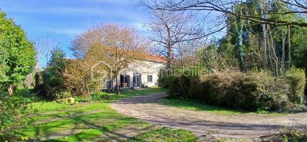 À seulement 1 km maximum de la ville et de toutes les commodités, au bout d’un chemin paisible où le silence n’est troublé que par la nature, découvrez cette magnifique maison en pierres de taille et moellons datant des années 1900, non mitoyenne, nichée au cœur d’un écrin de verdure de 5 191 m². Une propriété rare de 379 m² habitables, idéale pour les amoureux de calme, d’espace et d’authenticité.

Dès l’entrée, les volumes impressionnent : un séjour de 64 m² sublimé par une mezzanine de 40 m² qui surplombe la pièce et renforce le cachet et le caractère des lieux, un petit salon plus intime pour recevoir, une grande salle à manger conviviale et une cuisine séparée, moderne, aménagée et équipée. La maison offre au rez-de-chaussée une belle chambre de 20 m² avec sa suite parentale comprenant salle de bain, douche et toilettes séparées, ainsi qu’un WC indépendant. Deux cheminées agrémentent la maison, dont une avec insert, apportant chaleur et atmosphère d’antan. Au rez-de-chaussée, les ouvertures sont en double vitrage bois et les baies vitrées en aluminium, alliant confort et respect du style de la bâtisse.

À l’étage, trois chambres de 17 m², 14 m² et 13 m² se partagent un palier de 8 m². Les fenêtres y sont en simple vitrage, conservant l’esprit authentique de l’étage.

Un studio indépendant de 60 m², entièrement refait à neuf, complète ce bien et offre de très belles possibilités. Il dispose d’une chambre de 16 m², d’une agréable pièce de vie de 25 m² avec cuisine équipée, d’une salle de bain neuve, d’une salle d’eau avec cabine de douche, d’un WC séparé ainsi que d’un coin nuit avec lits superposés. À l’entrée du studio, une terrasse avec auvent accueille table et chaises pour profiter des beaux jours en toute tranquillité. Idéal pour recevoir famille et amis, développer une activité professionnelle ou envisager un projet locatif.

À l’extérieur, le terrain arboré de 5 191 m² invite à la détente avec une piscine 9 x 4,5 m, une cuisine d’été, un grand garage de 130 m² et une cave. La toiture est en bon état. L’assainissement est individuel et non conforme.

Le DPE est classé C en performance énergétique et A en émissions de gaz à effet de serre, un excellent équilibre pour une demeure de caractère. La maison est équipée d’une chaudière à pellets nouvelle génération assurant un confort performant et économique.

Les matériaux utilisés sont de bonne qualité, alliant robustesse et longévité, dans le respect du bâti ancien. Cette propriété séduira particulièrement les amoureux de l’authenticité, de la pierre et des demeures de caractère, à la recherche d’un lieu chargé d’histoire où le charme de l’ancien s’exprime pleinement, tout en restant proche de la ville.