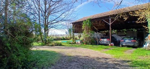 À seulement 1 km maximum de la ville et de toutes les commodités, au bout d’un chemin paisible où le silence n’est troublé que par la nature, découvrez cette magnifique maison en pierres de taille et moellons datant des années 1900, non mitoyenne, nichée au cœur d’un écrin de verdure de 5 191 m². Une propriété rare de 379 m² habitables, idéale pour les amoureux de calme, d’espace et d’authenticité.

Dès l’entrée, les volumes impressionnent : un séjour de 64 m² sublimé par une mezzanine de 40 m² qui surplombe la pièce et renforce le cachet et le caractère des lieux, un petit salon plus intime pour recevoir, une grande salle à manger conviviale et une cuisine séparée, moderne, aménagée et équipée. La maison offre au rez-de-chaussée une belle chambre de 20 m² avec sa suite parentale comprenant salle de bain, douche et toilettes séparées, ainsi qu’un WC indépendant. Deux cheminées agrémentent la maison, dont une avec insert, apportant chaleur et atmosphère d’antan. Au rez-de-chaussée, les ouvertures sont en double vitrage bois et les baies vitrées en aluminium, alliant confort et respect du style de la bâtisse.

À l’étage, trois chambres de 17 m², 14 m² et 13 m² se partagent un palier de 8 m². Les fenêtres y sont en simple vitrage, conservant l’esprit authentique de l’étage.

Un studio indépendant de 60 m², entièrement refait à neuf, complète ce bien et offre de très belles possibilités. Il dispose d’une chambre de 16 m², d’une agréable pièce de vie de 25 m² avec cuisine équipée, d’une salle de bain neuve, d’une salle d’eau avec cabine de douche, d’un WC séparé ainsi que d’un coin nuit avec lits superposés. À l’entrée du studio, une terrasse avec auvent accueille table et chaises pour profiter des beaux jours en toute tranquillité. Idéal pour recevoir famille et amis, développer une activité professionnelle ou envisager un projet locatif.

À l’extérieur, le terrain arboré de 5 191 m² invite à la détente avec une piscine 9 x 4,5 m, une cuisine d’été, un grand garage de 130 m² et une cave. La toiture est en bon état. L’assainissement est individuel et non conforme.

Le DPE est classé C en performance énergétique et A en émissions de gaz à effet de serre, un excellent équilibre pour une demeure de caractère. La maison est équipée d’une chaudière à pellets nouvelle génération assurant un confort performant et économique.

Les matériaux utilisés sont de bonne qualité, alliant robustesse et longévité, dans le respect du bâti ancien. Cette propriété séduira particulièrement les amoureux de l’authenticité, de la pierre et des demeures de caractère, à la recherche d’un lieu chargé d’histoire où le charme de l’ancien s’exprime pleinement, tout en restant proche de la ville.