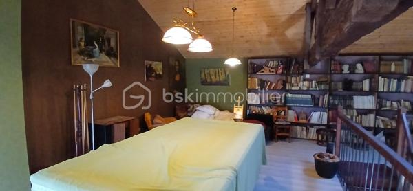 À seulement 1 km maximum de la ville et de toutes les commodités, au bout d’un chemin paisible où le silence n’est troublé que par la nature, découvrez cette magnifique maison en pierres de taille et moellons datant des années 1900, non mitoyenne, nichée au cœur d’un écrin de verdure de 5 191 m². Une propriété rare de 379 m² habitables, idéale pour les amoureux de calme, d’espace et d’authenticité.

Dès l’entrée, les volumes impressionnent : un séjour de 64 m² sublimé par une mezzanine de 40 m² qui surplombe la pièce et renforce le cachet et le caractère des lieux, un petit salon plus intime pour recevoir, une grande salle à manger conviviale et une cuisine séparée, moderne, aménagée et équipée. La maison offre au rez-de-chaussée une belle chambre de 20 m² avec sa suite parentale comprenant salle de bain, douche et toilettes séparées, ainsi qu’un WC indépendant. Deux cheminées agrémentent la maison, dont une avec insert, apportant chaleur et atmosphère d’antan. Au rez-de-chaussée, les ouvertures sont en double vitrage bois et les baies vitrées en aluminium, alliant confort et respect du style de la bâtisse.

À l’étage, trois chambres de 17 m², 14 m² et 13 m² se partagent un palier de 8 m². Les fenêtres y sont en simple vitrage, conservant l’esprit authentique de l’étage.

Un studio indépendant de 60 m², entièrement refait à neuf, complète ce bien et offre de très belles possibilités. Il dispose d’une chambre de 16 m², d’une agréable pièce de vie de 25 m² avec cuisine équipée, d’une salle de bain neuve, d’une salle d’eau avec cabine de douche, d’un WC séparé ainsi que d’un coin nuit avec lits superposés. À l’entrée du studio, une terrasse avec auvent accueille table et chaises pour profiter des beaux jours en toute tranquillité. Idéal pour recevoir famille et amis, développer une activité professionnelle ou envisager un projet locatif.

À l’extérieur, le terrain arboré de 5 191 m² invite à la détente avec une piscine 9 x 4,5 m, une cuisine d’été, un grand garage de 130 m² et une cave. La toiture est en bon état. L’assainissement est individuel et non conforme.

Le DPE est classé C en performance énergétique et A en émissions de gaz à effet de serre, un excellent équilibre pour une demeure de caractère. La maison est équipée d’une chaudière à pellets nouvelle génération assurant un confort performant et économique.

Les matériaux utilisés sont de bonne qualité, alliant robustesse et longévité, dans le respect du bâti ancien. Cette propriété séduira particulièrement les amoureux de l’authenticité, de la pierre et des demeures de caractère, à la recherche d’un lieu chargé d’histoire où le charme de l’ancien s’exprime pleinement, tout en restant proche de la ville.