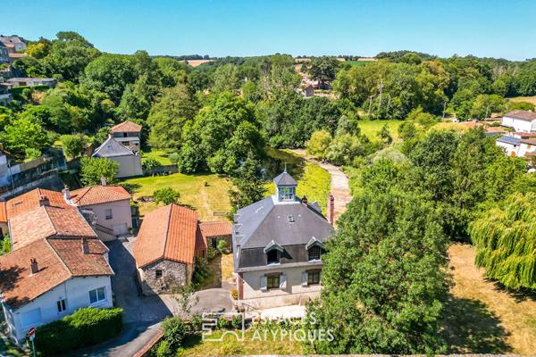 Un ancien moulin revisité avec élégance entre ciel et rivière