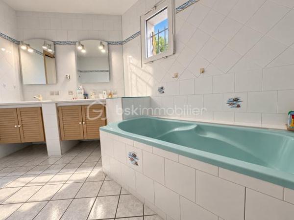 BSK Immobilier vous propose cette maison familiale située dans un environnement champêtre et particulièrement calme, offrant un cadre de vie paisible tout en restant à proximité des commodités.

D’une surface habitable de 132 m², elle est édifiée sur un terrain entièrement clos de 1 492 m², exposé plein sud et agrémenté d’une piscine de 7 × 4 mètres.

La maison s’organise sur plusieurs niveaux.

Dès l’entrée, vous découvrirez un placard à deux vantaux. L’espace de vie se compose d’un agréable séjour de 34,50 m² et d’une cuisine équipée de 10,50 m², installée en 2024. Celle-ci comprend un lave-vaisselle, une plaque de cuisson, une hotte, un four et un micro-ondes, avec un accès direct à la terrasse.

En demi-niveau, la partie nuit climatisée accueille trois chambres de 11,30 m², 11,30 m² et 13,40 m². Les trois chambres disposent d’un sol en parquet et de placards. L’une d’elles bénéficie également d’une porte-fenêtre donnant directement sur l’extérieur.

Ce niveau comprend également une salle de bains de 7,40 m² avec baignoire, double vasque, sèche-serviettes et dressing, une salle d’eau de 2,90 m² avec douche et vasque, ainsi qu’un WC suspendu indépendant de 1,30 m².

Au sous-sol, vous bénéficierez d’une quatrième chambre carrelée de 11,10 m², d’une buanderie de 8 m² et d’une salle d’eau de 2,30 m² comprenant une douche, une vasque et un WC. Un garage de 30 m² complète ce niveau.

La propriété dispose également d’une cave d’environ 30 m², dont le sol est en partie carrelé et en partie en terre battue, ainsi que d’un petit abri extérieur.

Côté équipements, la maison bénéficie de menuiseries en PVC double vitrage, de volets roulants sur l’ensemble des ouvertures et d’un chauffage électrique au sol. La production d’eau chaude est assurée par un ballon de 300 litres, remplacé en 2024. Un conduit de cheminée permet également d’envisager l’installation d’un poêle à bois ou d’un autre mode de chauffage complémentaire.

Le portail électrique, le digicode et le système d’alarme apportent confort et sécurité. Trois points d’eau extérieurs facilitent l’entretien du terrain.

La maison est raccordée au tout-à-l’égout et à la fibre optique.

Taxe foncière : 1 692 €.

Une maison spacieuse et fonctionnelle, idéale pour les personnes recherchant le calme, de beaux volumes et un agréable cadre de vie à la campagne, sans être isolées.
A visiter sans tarder !!!