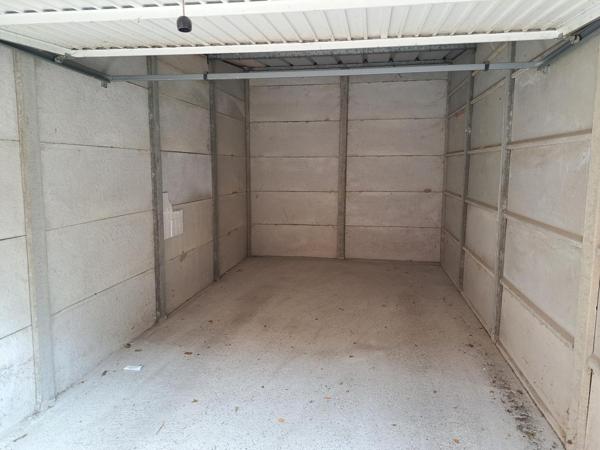 Garage fermé dans copropriété récente et sécurisée.