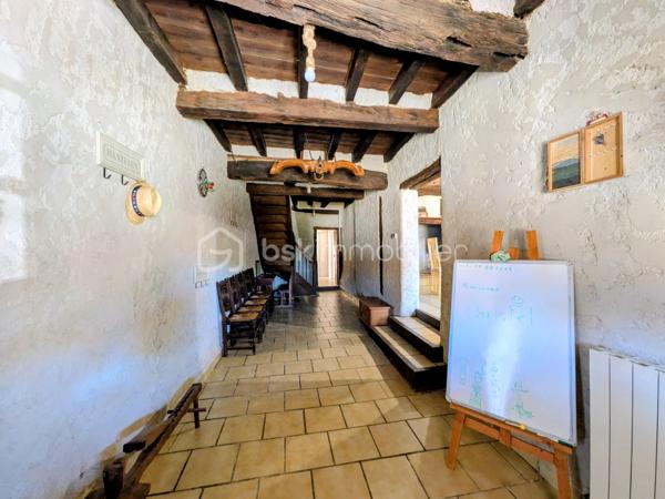 Certaines maisons ont une histoire… et celle-ci a su conserver toute son âme.  Située dans un paisible village gersois, à seulement une douzaine de minutes de Fleurance et une quinzaine de minutes de Mauvezin, cette authentique maison de 1860 séduit par son alliance rare entre le charme de l'ancien et le confort d'aujourd'hui.

Pierres apparentes, poutres, matériaux nobles et volumes généreux créent immédiatement une atmosphère chaleureuse et pleine de caractère.

Dès l’entrée, vous découvrirez une distribution typique des anciennes maisons gersoises :  d’un côté, une grande cuisine conviviale d’environ 19,5 m², avec sa cheminée ancienne fonctionnelle, complétée par un cellier. De l’autre, un magnifique séjour d’environ 45 m², également agrémenté d’une cheminée en pierre, ouvert sur un patio intimiste d’environ 64 m² grâce à une grande baie vitrée.

Cet extérieur sans vis-à-vis offre un véritable espace de vie supplémentaire : repas d’été, moments en famille ou entre amis, détente… tout en profitant d’un entretien réduit.

Une salle de bain pleine de charme associant pierre apparente et confort actuel, et des toilettes séparées avec coin buanderie ,complètent le rez-de-chaussée.  À l’étage, l’espace nuit propose 4 chambres, dont une superbe chambre de plus de 24 m² avec salle d’eau privative, une deuxième chambre avec également son espace d’eau, et deux autres chambres confortables.

Et parce que cette maison possède une touche d’originalité rare… une porte dissimulée derrière ce qui semble être un simple placard dévoile une pièce secrète de 6,4 m² : salle de jeux, espace lecture, cachette des enfants ou petit bureau confidentiel… à chacun d’imaginer son usage.

Équipée d'une pompe à chaleur, cette bâtisse bénéficie d'un excellent classement énergétique DPE A, un véritable atout pour une maison de cette époque !

Le spa actuellement installé pourra être acquis en complément. Une fois retiré, cet espace retrouvera sa fonction de garage.


Cette propriété est aujourd'hui la résidence principale de ses propriétaires tout en étant exploitée en hébergement touristique labellisé Gîtes de France.    Sa configuration permet aussi bien une vie de famille confortable que la poursuite d'une activité touristique, offrant ainsi de nombreuses possibilités selon les projets de chacun. Les deux chambres disposant de leur salle d'eau privative constituent d'ailleurs un véritable atout pour accueillir des voyageurs dans d'excellentes conditions.


Les plus qui font la différence  :

- Maison de caractère rénovée
- DPE A (exceptionnel pour une bâtisse de cette époque)
- Patio de 64 m² sans vis-à-vis
- 4 chambres dont 2 avec salle d'eau privative
- Garage
- Deux cheminées fonctionnelles
- Actuellement exploitée en Gîtes de France (activité pouvant être poursuivie selon le projet de l'acquéreur)
- Potentiel de revenus complémentaires
- Taxe foncière : 373 €
- Et la fameuse pièce secrète !

Plus qu'une maison, c'est un véritable lieu de vie où le charme de l'ancien, le confort moderne et les possibilités qu'offre cette propriété sauront séduire aussi bien une famille en quête d'authenticité qu'un acquéreur souhaitant développer une activité touristique. Une visite suffira pour en ressentir toute l'atmosphère.

*** VISITE VIRTUELLE SUR DEMANDE ***