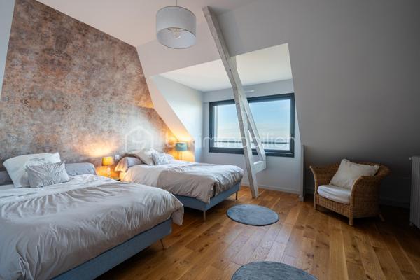 Située en surplomb de la plage de Bonne Source à Pornichet, au coeur d’une impasse confidentielle, cette villa de caractère bénéficie d’un emplacement privilégié face à l’océan. À l’abri des regards et sans vis-à-vis, elle offre un cadre de vie rare où la quiétude des lieux s’accorde avec la beauté du littoral.

Édifiée en 1945 et entièrement repensée par un architecte en 2019, la propriété conjugue aujourd’hui le charme de l’architecture balnéaire d’origine avec une rénovation contemporaine aux prestations soignées. Développant environ 217 m² au sol dont 195 m² habitables sur un terrain de 698 m², elle profite d’une orientation sud-ouest qui sublime la lumière naturelle et met en valeur les panoramas maritimes.

Dès l’entrée, la villa dévoile une atmosphère chaleureuse et des volumes harmonieusement pensés. Le rez-de-chaussée s’organise autour d’un vaste espace de vie tourné vers l’océan. Le salon, agrémenté d’une cheminée à insert, dialogue avec la salle à manger et se prolonge vers une cuisine entièrement aménagée et équipée d’électroménagers haut de gamme, sublimée par un plan de travail en granit. Une arrière-cuisine fonctionnelle complète cet ensemble.

De larges ouvertures à galandage effacent les frontières entre intérieur et extérieur et prolongent naturellement la pièce de vie vers la terrasse face mer. Cet espace offre une vue exceptionnelle sur l’océan et la plage de Bonne Source, avec en arrière-plan le port de Pornichet, la baie de La Baule et la Pointe de Penchâteau. Depuis la terrasse, un accès direct permet de rejoindre le chemin côtier et la plage.

Le premier étage accueille l’espace nuit. Une chambre tournée vers la mer dispose de rangements intégrés et communique avec une salle d’eau partagée avec une seconde chambre également orientée vers l’océan. Une troisième chambre profite quant à elle d’une salle d’eau indépendante et d’un balcon privatif.

Le dernier niveau dévoile un espace remarquable entièrement dédié à un univers parental. Baigné de lumière, il accueille un vaste salon panoramique offrant une vue spectaculaire sur l’océan. Pensé comme un véritable lieu de contemplation, cet étage comprend également une grande chambre face mer ainsi qu’une salle d’eau avec toilettes, formant un ensemble intime et privilégié.

Le sous-sol accueille plusieurs espaces techniques et fonctionnels, dont une chaufferie, une salle d’eau avec douche retour de plage, des toilettes indépendantes ainsi que différents espaces de stockage.
À l’extérieur, le jardin paysagé complète harmonieusement l’ensemble et bénéficie d’un accès direct au littoral.

Cette propriété rare offre un cadre de vie exceptionnel, entre horizon marin et douceur de vivre, avec un accès direct à la plage et une proximité immédiate avec les commerces de Pornichet.