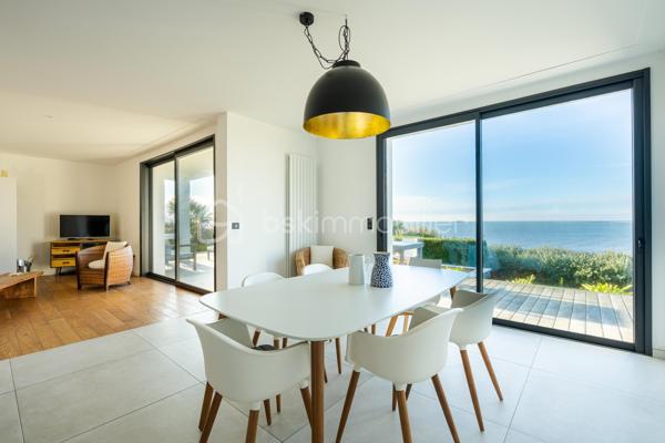 Située en surplomb de la plage de Bonne Source à Pornichet, au coeur d’une impasse confidentielle, cette villa de caractère bénéficie d’un emplacement privilégié face à l’océan. À l’abri des regards et sans vis-à-vis, elle offre un cadre de vie rare où la quiétude des lieux s’accorde avec la beauté du littoral.

Édifiée en 1945 et entièrement repensée par un architecte en 2019, la propriété conjugue aujourd’hui le charme de l’architecture balnéaire d’origine avec une rénovation contemporaine aux prestations soignées. Développant environ 217 m² au sol dont 195 m² habitables sur un terrain de 698 m², elle profite d’une orientation sud-ouest qui sublime la lumière naturelle et met en valeur les panoramas maritimes.

Dès l’entrée, la villa dévoile une atmosphère chaleureuse et des volumes harmonieusement pensés. Le rez-de-chaussée s’organise autour d’un vaste espace de vie tourné vers l’océan. Le salon, agrémenté d’une cheminée à insert, dialogue avec la salle à manger et se prolonge vers une cuisine entièrement aménagée et équipée d’électroménagers haut de gamme, sublimée par un plan de travail en granit. Une arrière-cuisine fonctionnelle complète cet ensemble.

De larges ouvertures à galandage effacent les frontières entre intérieur et extérieur et prolongent naturellement la pièce de vie vers la terrasse face mer. Cet espace offre une vue exceptionnelle sur l’océan et la plage de Bonne Source, avec en arrière-plan le port de Pornichet, la baie de La Baule et la Pointe de Penchâteau. Depuis la terrasse, un accès direct permet de rejoindre le chemin côtier et la plage.

Le premier étage accueille l’espace nuit. Une chambre tournée vers la mer dispose de rangements intégrés et communique avec une salle d’eau partagée avec une seconde chambre également orientée vers l’océan. Une troisième chambre profite quant à elle d’une salle d’eau indépendante et d’un balcon privatif.

Le dernier niveau dévoile un espace remarquable entièrement dédié à un univers parental. Baigné de lumière, il accueille un vaste salon panoramique offrant une vue spectaculaire sur l’océan. Pensé comme un véritable lieu de contemplation, cet étage comprend également une grande chambre face mer ainsi qu’une salle d’eau avec toilettes, formant un ensemble intime et privilégié.

Le sous-sol accueille plusieurs espaces techniques et fonctionnels, dont une chaufferie, une salle d’eau avec douche retour de plage, des toilettes indépendantes ainsi que différents espaces de stockage.
À l’extérieur, le jardin paysagé complète harmonieusement l’ensemble et bénéficie d’un accès direct au littoral.

Cette propriété rare offre un cadre de vie exceptionnel, entre horizon marin et douceur de vivre, avec un accès direct à la plage et une proximité immédiate avec les commerces de Pornichet.