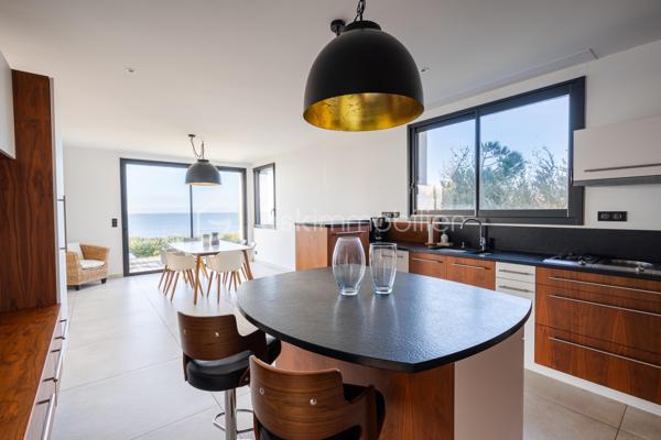 Située en surplomb de la plage de Bonne Source à Pornichet, au coeur d’une impasse confidentielle, cette villa de caractère bénéficie d’un emplacement privilégié face à l’océan. À l’abri des regards et sans vis-à-vis, elle offre un cadre de vie rare où la quiétude des lieux s’accorde avec la beauté du littoral.

Édifiée en 1945 et entièrement repensée par un architecte en 2019, la propriété conjugue aujourd’hui le charme de l’architecture balnéaire d’origine avec une rénovation contemporaine aux prestations soignées. Développant environ 217 m² au sol dont 195 m² habitables sur un terrain de 698 m², elle profite d’une orientation sud-ouest qui sublime la lumière naturelle et met en valeur les panoramas maritimes.

Dès l’entrée, la villa dévoile une atmosphère chaleureuse et des volumes harmonieusement pensés. Le rez-de-chaussée s’organise autour d’un vaste espace de vie tourné vers l’océan. Le salon, agrémenté d’une cheminée à insert, dialogue avec la salle à manger et se prolonge vers une cuisine entièrement aménagée et équipée d’électroménagers haut de gamme, sublimée par un plan de travail en granit. Une arrière-cuisine fonctionnelle complète cet ensemble.

De larges ouvertures à galandage effacent les frontières entre intérieur et extérieur et prolongent naturellement la pièce de vie vers la terrasse face mer. Cet espace offre une vue exceptionnelle sur l’océan et la plage de Bonne Source, avec en arrière-plan le port de Pornichet, la baie de La Baule et la Pointe de Penchâteau. Depuis la terrasse, un accès direct permet de rejoindre le chemin côtier et la plage.

Le premier étage accueille l’espace nuit. Une chambre tournée vers la mer dispose de rangements intégrés et communique avec une salle d’eau partagée avec une seconde chambre également orientée vers l’océan. Une troisième chambre profite quant à elle d’une salle d’eau indépendante et d’un balcon privatif.

Le dernier niveau dévoile un espace remarquable entièrement dédié à un univers parental. Baigné de lumière, il accueille un vaste salon panoramique offrant une vue spectaculaire sur l’océan. Pensé comme un véritable lieu de contemplation, cet étage comprend également une grande chambre face mer ainsi qu’une salle d’eau avec toilettes, formant un ensemble intime et privilégié.

Le sous-sol accueille plusieurs espaces techniques et fonctionnels, dont une chaufferie, une salle d’eau avec douche retour de plage, des toilettes indépendantes ainsi que différents espaces de stockage.
À l’extérieur, le jardin paysagé complète harmonieusement l’ensemble et bénéficie d’un accès direct au littoral.

Cette propriété rare offre un cadre de vie exceptionnel, entre horizon marin et douceur de vivre, avec un accès direct à la plage et une proximité immédiate avec les commerces de Pornichet.
