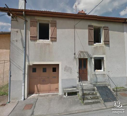 Une maison à usage d'habitation, mitoyenne d'un côté, comprenant :