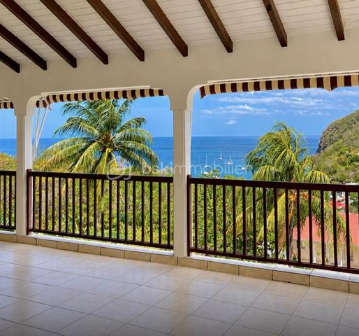 Découvrez cette magnifique propriété de 2 031 m² idéalement située sur les hauteurs de Deshaies, offrant une vue panoramique exceptionnelle sur la baie et un cadre de vie privilégié.

Cette propriété se distingue par ses volumes généreux, ses nombreuses ouvertures qui inondent les espaces de lumière naturelle tout au long de la journée et sa ventilation traversante, particulièrement appréciable sous le climat tropical. Les chambres climatisées assurent un confort optimal en toutes saisons.

La villa principale, aux prestations de qualité, s'organise autour d'une vaste pièce de vie baignée de lumière, sublimée par une remarquable hauteur sous plafond et une mezzanine ouverte qui accentue la sensation d'espace. La cuisine, conviviale et fonctionnelle, s'intègre harmonieusement à cet espace de vie. L'espace nuit comprend quatre chambres, dont une belle suite parentale. À l'extérieur, une vaste terrasse panoramique prolonge les pièces de vie et offre une vue imprenable sur la baie de Deshaies, idéale pour profiter des couchers de soleil.

La propriété comprend également deux appartements T2 totalement indépendants, parfaits pour accueillir famille et amis ou développer une activité de location saisonnière. Chaque T2 est composé d'une cuisine ouverte sur le séjour, d'une chambre, d'une salle d'eau et d'une terrasse privative permettant de profiter pleinement de l'environnement tropical en toute intimité.

Avec un total de 9 pièces, cette propriété représente une opportunité rare, alliant confort, potentiel locatif et qualité de vie.

Son emplacement est un véritable atout : à seulement quelques minutes des plages emblématiques de Grande Anse, des commerces, des restaurants et du charmant bourg de Deshaies, elle offre un équilibre parfait entre tranquillité, proximité des commodités et attractivité touristique.

Que vous recherchiez une résidence principale, une maison de vacances ou un investissement à fort potentiel, cette propriété saura vous séduire par son emplacement exceptionnel, ses prestations et son panorama unique sur l'une des plus belles baies de Guadeloupe.