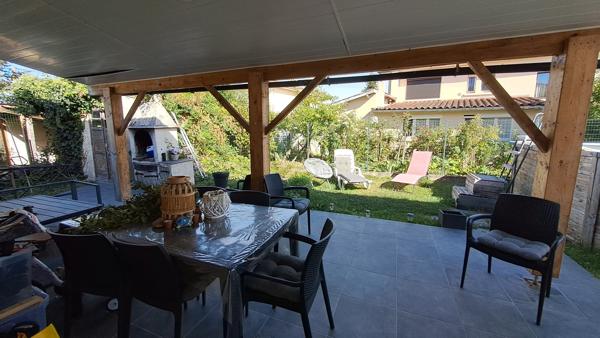 Maison familiale lumineuse avec grand espace de vie et terrasse couverte sur un terrain clos de 500m2.