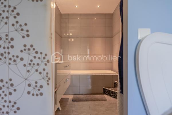 À Ferrières, dans un environnement calme et préservé, au cœur d’un cadre naturel entouré de montagnes, découvrez ce superbe duplex de 124 m², offrant un excellent compromis entre maison et appartement.

Situé dans un ancien corps de ferme, ce bien a été entièrement rénové avec goût. Il séduit par ses beaux volumes, sa circulation fluide entre les espaces et son atmosphère chaleureuse.

Au rez-de-chaussée, vous profitez d’une grande pièce de vie lumineuse de plus de 50 m², comprenant une cuisine ouverte, un espace repas et un salon. Moderne et fonctionnelle, la cuisine s’articule autour d’un îlot central convivial. Depuis la pièce de vie, vous accédez à une agréable terrasse en bois, idéale pour profiter du calme environnant. Un petit potager vient compléter ce bel extérieur.

Ce niveau dispose également d’une buanderie ainsi que d’un WC indépendant.

Un élégant escalier en métal apporte du caractère à l’ensemble et mène à l’étage. Une verrière ouvre les perspectives et renforce la luminosité de la mezzanine.

L’espace nuit se compose actuellement de deux chambres et d’une grande mezzanine, pouvant facilement être transformée en troisième chambre.

La chambre parentale, d’environ 20 m², bénéficie d’un dressing ainsi que d’une salle d’eau complète avec baignoire, douche et WC. La seconde chambre, d’environ 13 m², dispose également de sa propre douche.

Toiture et façade récentes, aucun travaux à prévoir.

Le bien fait partie d’une copropriété bénévole, sans frais de copropriété. Le chauffage est collectif avec comptage individuel, complété par un poêle à granulés apportant confort et convivialité.

Ce duplex dispose également de deux places de parking ainsi que d’une cave.

La commune de Ferrières offre un cadre naturel recherché, à proximité immédiate de la Mandallaz et à moins de 10 minutes de l’accès autoroute permettant de rejoindre Genève.

Un bien atypique et chaleureux, idéal pour ceux qui recherchent les volumes et le confort d’une maison, tout en conservant les avantages d’un appartement.