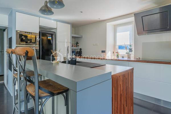 À Ferrières, dans un environnement calme et préservé, au cœur d’un cadre naturel entouré de montagnes, découvrez ce superbe duplex de 124 m², offrant un excellent compromis entre maison et appartement.

Situé dans un ancien corps de ferme, ce bien a été entièrement rénové avec goût. Il séduit par ses beaux volumes, sa circulation fluide entre les espaces et son atmosphère chaleureuse.

Au rez-de-chaussée, vous profitez d’une grande pièce de vie lumineuse de plus de 50 m², comprenant une cuisine ouverte, un espace repas et un salon. Moderne et fonctionnelle, la cuisine s’articule autour d’un îlot central convivial. Depuis la pièce de vie, vous accédez à une agréable terrasse en bois, idéale pour profiter du calme environnant. Un petit potager vient compléter ce bel extérieur.

Ce niveau dispose également d’une buanderie ainsi que d’un WC indépendant.

Un élégant escalier en métal apporte du caractère à l’ensemble et mène à l’étage. Une verrière ouvre les perspectives et renforce la luminosité de la mezzanine.

L’espace nuit se compose actuellement de deux chambres et d’une grande mezzanine, pouvant facilement être transformée en troisième chambre.

La chambre parentale, d’environ 20 m², bénéficie d’un dressing ainsi que d’une salle d’eau complète avec baignoire, douche et WC. La seconde chambre, d’environ 13 m², dispose également de sa propre douche.

Toiture et façade récentes, aucun travaux à prévoir.

Le bien fait partie d’une copropriété bénévole, sans frais de copropriété. Le chauffage est collectif avec comptage individuel, complété par un poêle à granulés apportant confort et convivialité.

Ce duplex dispose également de deux places de parking ainsi que d’une cave.

La commune de Ferrières offre un cadre naturel recherché, à proximité immédiate de la Mandallaz et à moins de 10 minutes de l’accès autoroute permettant de rejoindre Genève.

Un bien atypique et chaleureux, idéal pour ceux qui recherchent les volumes et le confort d’une maison, tout en conservant les avantages d’un appartement.