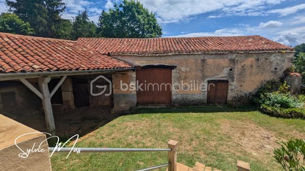 Aux portes du Périgord, un véritable havre de paix dans un hameau de campagne.
Nichée dans un environnement calme et préservé, cette charmante propriété de caractère invite à ralentir le rythme et à retrouver le plaisir des choses simples.
Dès l'arrivée, le charme opère. Une jolie cour intérieure constitue le cœur de la propriété et relie harmonieusement l'habitation, le vaste auvent et les dépendances dans une atmosphère authentique et chaleureuse.

L'habitation, d'environ 48 m² habitables, offre un cadre confortable pour une résidence principale comme pour une maison de vacances. Elle comprend une agréable pièce de vie avec cuisine ouverte, une chambre avec placard, un bureau pouvant accueillir un couchage d'appoint ainsi qu'une salle d'eau avec WC. Les menuiseries PVC double vitrage, les murs doublés et le chauffage central au fioul assurent un confort appréciable. En rez-de-jardin, une cave et la chaufferie complètent l'habitation.

Sous le superbe auvent, un ancien four à pain témoigne de l'histoire des lieux. Cet espace couvert, chargé de caractère, se prête naturellement aux repas de famille, aux soirées d'été entre amis ou à l'aménagement d'un lieu de vie convivial.

Depuis la cour, un passage mène vers le magnifique parc arboré de 5 050 m². Fruitiers, conifères majestueux et arbres matures composent un écrin de verdure exceptionnel où chaque saison offre un spectacle différent. Un cadre rare qui procure une véritable sensation d'espace et de sérénité.
La propriété dispose également d'une belle grange en pierre aux volumes généreux et au cachet préservé elle ouvre la voie à de nombreux projets : atelier d'artiste, gîte, extension de l'habitation, ou activité professionnelle.

Une importante réserve d'eau enterrée complète utilement cet ensemble plein de potentiel.

Authentique, paisible et pleine de possibilités, cette propriété séduira les amoureux de nature, de patrimoine et de lieux chargés d'histoire. Un refuge de campagne où l'on vient chercher la tranquillité... et où l'on se projette immédiatement !