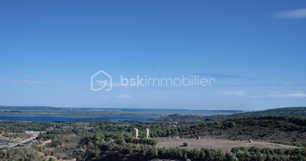 Et si votre futur commençait ici ?

Imaginez votre maison perchée sur les hauteurs de Narbonne, profitant chaque jour d’un panorama exceptionnel dans un environnement calme et privilégié…

Au cœur du très recherché lotissement L’Odéon, découvrez ce superbe terrain constructible de 428 m², entièrement viabilisé, prêt à accueillir le projet de vie dont vous rêvez.

Sa position dominante offre un cadre unique. Selon l’implantation de votre future maison et les conditions météorologiques, vous pourrez profiter d’une vue dégagée sur la ville de Narbonne, les étangs, le massif de la Clape et, par temps clair, jusqu’à la chaîne des Pyrénées. Un décor qui évolue au fil des saisons et des lumières, pour un quotidien empreint de sérénité.

Ce terrain bénéficie d’un environnement résidentiel de qualité, où calme et nature se conjuguent avec la proximité de toutes les commodités : commerces, établissements scolaires, infrastructures sportives, gare, accès rapide à l’autoroute A9 et aux plages méditerranéennes.

Entièrement viabilisé, il vous permettra de concrétiser votre projet de construction dans les meilleures conditions.

Afin de vous aider à vous projeter, une simulation d’implantation d’une maison sur le terrain est disponible. Elle vous permettra de mieux visualiser le potentiel de cette parcelle et d’imaginer votre futur lieu de vie.

Une opportunité rare sur les Hauts de Narbonne, alliant emplacement privilégié, qualité de vie et panorama remarquable.

Une visite suffit souvent pour tomber sous le charme… Contactez moi dès aujourd’hui pour découvrir ce terrain et échanger sur votre projet immobilier.