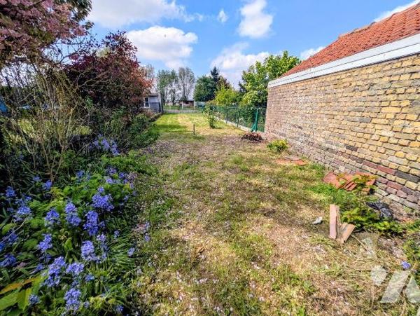 Maison mitoyenne à rénover avec jardin. Composée d'un séjour, une chambre et une cuisine. Grenier.