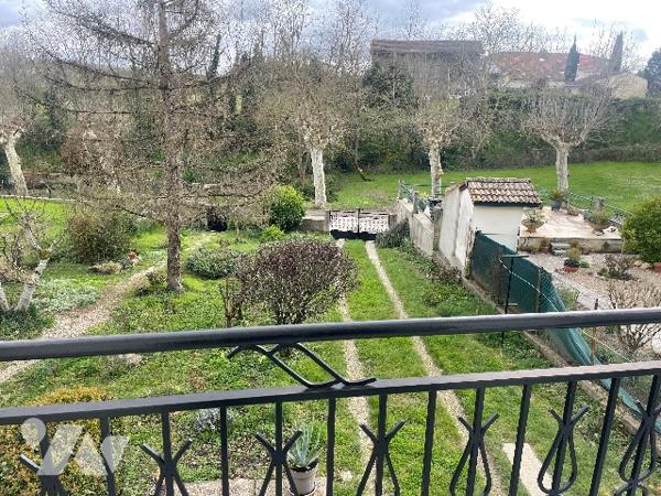 Maison de village avec grand garage et jardin.