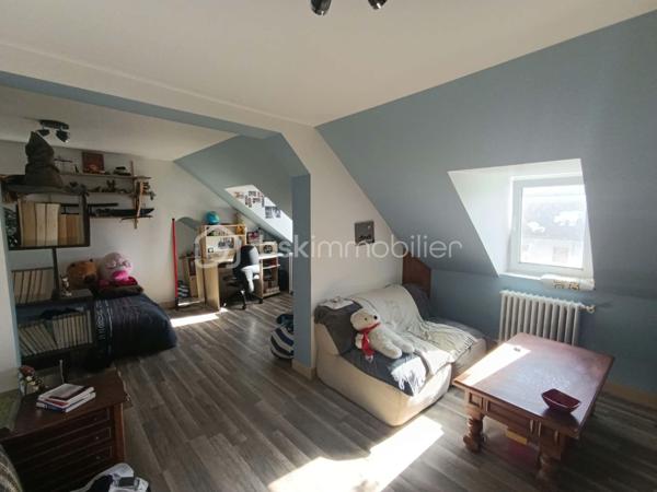 À seulement 3 minutes à pied du centre-bourg et de toutes les commodités, découvrez cette maison offrant de beaux volumes, plusieurs chambres et un ensemble de dépendances, le tout sur un agréable jardin.

La maison se compose au rez-de-chaussée :

d'une entrée,
un salon chaleureux avec cheminée équipée d’un foyer fermé,
un séjour,
une salle à manger,
une cuisine,
un WC indépendant,
une chaufferie avec chauffage au gaz de ville.

Au premier étage :

un palier desservant les différentes pièces,

une salle de bains avec WC,
trois chambres,
ainsi qu’une pièce mansardée située à l’arrière de deux chambres, offrant la possibilité d’aménager des espaces de rangement ou un dressing.

Au deuxième étage :

une grande chambre,
deux autres chambres à remettre en état, offrant ainsi un potentiel supplémentaire.
une salle d’eau avec WC, 

La propriété bénéficie également de plusieurs bâtiments annexes, comprenant notamment des ateliers, une cave et un garage, ainsi qu’un porche.

À l’extérieur, vous profiterez d’un jardin offrant un espace agréable pour les beaux jours.

Une maison aux nombreuses possibilités d’aménagement, idéale pour une famille à la recherche d’espace, tout en souhaitant rester à proximité immédiate des commerces et services du centre-bourg.

Les atouts : proximité du centre-bourg • beaux volumes • 6 chambres potentielles • dépendances • garage • ateliers • cave • jardin • porche • chauffage au gaz de ville.