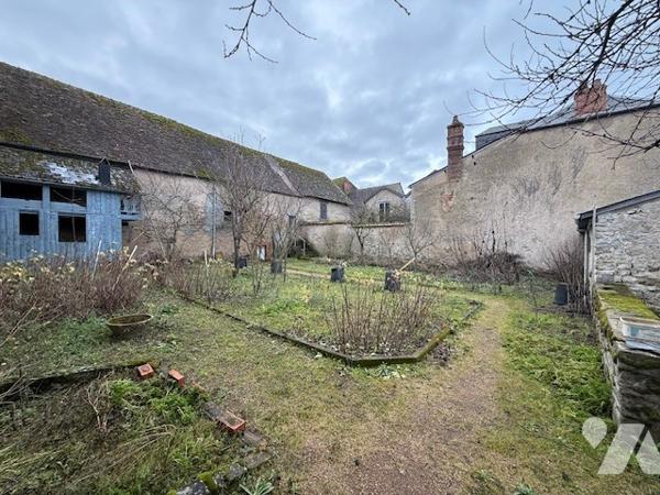 Dépendances comprenant deux garages, anciennes écuries, cave et jardin clos.