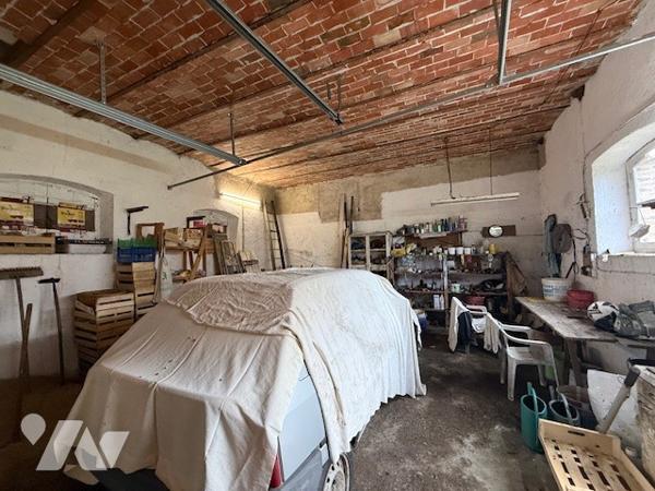 Dépendances comprenant deux garages, anciennes écuries, cave et jardin clos.