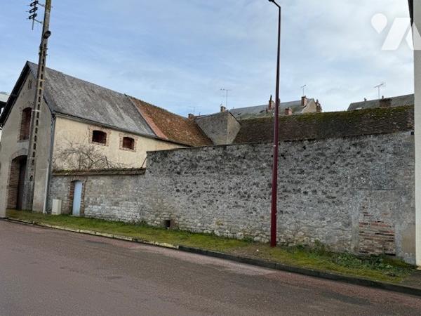 Dépendances comprenant deux garages, anciennes écuries, cave et jardin clos.
