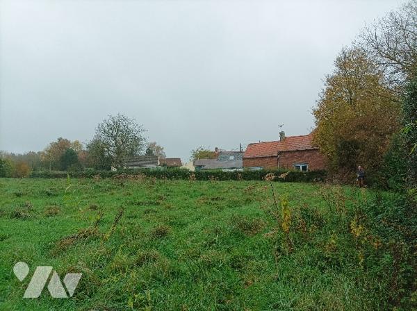 Dans village recherché, terrain à bâtir, plat, avec grande façade, proximité immédiate de l'A26.
