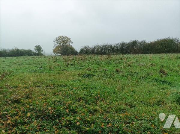 Dans village recherché, terrain à bâtir, plat, avec grande façade, proximité immédiate de l'A26.