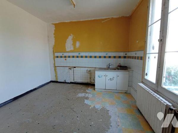 Maison de ville sans terrain à rénover, mitoyenne d'un côté et comprenant : 
- au rez-de-chaus...