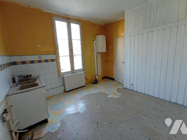 Maison de ville sans terrain à rénover, mitoyenne d'un côté et comprenant : 
- au rez-de-chaus...