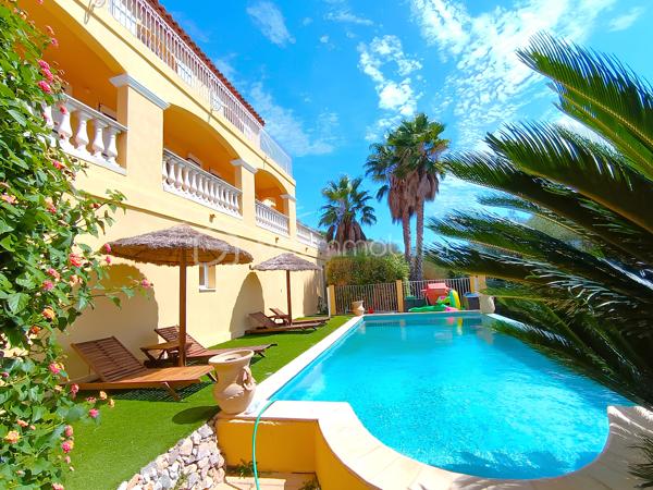 OLLIOULES – LA COURTINE

Villa avec vue panoramique, piscine à débordement et appartement indépendant

Une vue panoramique dont on ne se lasse jamais, une piscine à débordement semblant se fondre dans le paysage et un environnement préservé à quelques minutes seulement du centre d'Ollioules.

Dans l'un des secteurs résidentiels les plus recherchés de la commune, cette propriété offre un cadre de vie privilégié où intimité, lumière et panorama exceptionnel se conjuguent au quotidien.

Nichée au bout d'une impasse, à l'abri des regards, cette élégante villa construite en 2003 développe environ 225 m² habitables sur un terrain paysager de 1 662 m².

Dès les premiers instants, le charme opère.

Les volumes généreux, la luminosité omniprésente et l'ouverture permanente sur l'extérieur créent une atmosphère à la fois chaleureuse et apaisante.

Le niveau principal accueille plus de 100 m² de plain-pied baignés de lumière grâce à son exposition Sud-Sud-Ouest.

Il comprend :

• Une entrée avec dressing
• Un vaste espace de vie de près de 64 m² avec cheminée
• Une cuisine familiale entièrement équipée
• Une suite parentale avec salle d'eau privative et accès direct à la terrasse

Chaque espace profite pleinement de la vue spectaculaire qui accompagne le quotidien et prolonge naturellement les pièces de vie vers l'extérieur.

À l'étage, l'espace nuit accueille trois chambres bénéficiant chacune d'un accès direct au balcon panoramique ainsi qu'un bureau pouvant faire office de chambre supplémentaire, d'espace télétravail ou de salle de loisirs. Les autres espaces nuit se répartissent entre le niveau principal et l'appartement indépendant.

Pensée pour accueillir famille et amis dans les meilleures conditions, la propriété dispose également d'un appartement indépendant d'environ 54 m² avec terrasse privative.

Véritable atout de la propriété, cet espace complémentaire permet de recevoir en toute intimité, d'exercer une activité professionnelle indépendante ou d'envisager un revenu locatif.

À l'extérieur, le spectacle continue.

La piscine à débordement de 9 x 4 mètres semble se fondre dans le paysage et offre un point de vue privilégié sur les collines du littoral varois.

Les terrasses, espaces détente et coins repas invitent à profiter pleinement du climat méditerranéen et des couchers de soleil qui rythment les saisons.

Deux vastes restanques supplémentaires offrent encore de nombreuses possibilités d'aménagement selon vos envies : jardin méditerranéen, terrain de pétanque, espace de loisirs ou projet paysager personnalisé.

Les prestations :

• Environ 225 m² habitables
• Terrain de 1 662 m²
• Construction de 2003
• 5 chambres + 1 bureau
• 3 salles d'eau dont une à personnaliser
• Appartement indépendant de 54 m²
• Piscine à débordement 9 x 4 m
• Pompe à chaleur récente (2024)
• Climatisation réversible
• Double vitrage
• Garage de 20 m²
• Nombreuses places de stationnement
• Portail automatique

À seulement quelques minutes du centre historique d'Ollioules, des commerces, des écoles et des principaux axes de communication, cette propriété conjugue parfaitement tranquillité, confort et proximité.

Les propriétés offrant une telle combinaison de vue panoramique, d'intimité, d'espaces extérieurs, de potentiel d'accueil et de proximité avec le centre d'Ollioules sont particulièrement rares sur le secteur.

Ici, les saisons défilent, la lumière évolue au fil des heures et le panorama reste toujours aussi spectaculaire.

Visite exclusivement sur rendez-vous.

Kévin LEXA
BSK Immobilier
Disponible 7J/7