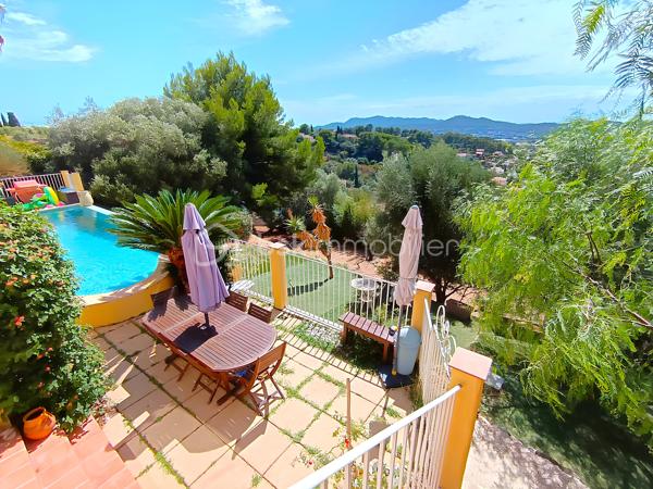 OLLIOULES – LA COURTINE

Villa avec vue panoramique, piscine à débordement et appartement indépendant

Une vue panoramique dont on ne se lasse jamais, une piscine à débordement semblant se fondre dans le paysage et un environnement préservé à quelques minutes seulement du centre d'Ollioules.

Dans l'un des secteurs résidentiels les plus recherchés de la commune, cette propriété offre un cadre de vie privilégié où intimité, lumière et panorama exceptionnel se conjuguent au quotidien.

Nichée au bout d'une impasse, à l'abri des regards, cette élégante villa construite en 2003 développe environ 225 m² habitables sur un terrain paysager de 1 662 m².

Dès les premiers instants, le charme opère.

Les volumes généreux, la luminosité omniprésente et l'ouverture permanente sur l'extérieur créent une atmosphère à la fois chaleureuse et apaisante.

Le niveau principal accueille plus de 100 m² de plain-pied baignés de lumière grâce à son exposition Sud-Sud-Ouest.

Il comprend :

• Une entrée avec dressing
• Un vaste espace de vie de près de 64 m² avec cheminée
• Une cuisine familiale entièrement équipée
• Une suite parentale avec salle d'eau privative et accès direct à la terrasse

Chaque espace profite pleinement de la vue spectaculaire qui accompagne le quotidien et prolonge naturellement les pièces de vie vers l'extérieur.

À l'étage, l'espace nuit accueille trois chambres bénéficiant chacune d'un accès direct au balcon panoramique ainsi qu'un bureau pouvant faire office de chambre supplémentaire, d'espace télétravail ou de salle de loisirs. Les autres espaces nuit se répartissent entre le niveau principal et l'appartement indépendant.

Pensée pour accueillir famille et amis dans les meilleures conditions, la propriété dispose également d'un appartement indépendant d'environ 54 m² avec terrasse privative.

Véritable atout de la propriété, cet espace complémentaire permet de recevoir en toute intimité, d'exercer une activité professionnelle indépendante ou d'envisager un revenu locatif.

À l'extérieur, le spectacle continue.

La piscine à débordement de 9 x 4 mètres semble se fondre dans le paysage et offre un point de vue privilégié sur les collines du littoral varois.

Les terrasses, espaces détente et coins repas invitent à profiter pleinement du climat méditerranéen et des couchers de soleil qui rythment les saisons.

Deux vastes restanques supplémentaires offrent encore de nombreuses possibilités d'aménagement selon vos envies : jardin méditerranéen, terrain de pétanque, espace de loisirs ou projet paysager personnalisé.

Les prestations :

• Environ 225 m² habitables
• Terrain de 1 662 m²
• Construction de 2003
• 5 chambres + 1 bureau
• 3 salles d'eau dont une à personnaliser
• Appartement indépendant de 54 m²
• Piscine à débordement 9 x 4 m
• Pompe à chaleur récente (2024)
• Climatisation réversible
• Double vitrage
• Garage de 20 m²
• Nombreuses places de stationnement
• Portail automatique

À seulement quelques minutes du centre historique d'Ollioules, des commerces, des écoles et des principaux axes de communication, cette propriété conjugue parfaitement tranquillité, confort et proximité.

Les propriétés offrant une telle combinaison de vue panoramique, d'intimité, d'espaces extérieurs, de potentiel d'accueil et de proximité avec le centre d'Ollioules sont particulièrement rares sur le secteur.

Ici, les saisons défilent, la lumière évolue au fil des heures et le panorama reste toujours aussi spectaculaire.

Visite exclusivement sur rendez-vous.

Kévin LEXA
BSK Immobilier
Disponible 7J/7